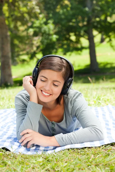 Kobieta słuchać muzyki w parku — Zdjęcie stockowe