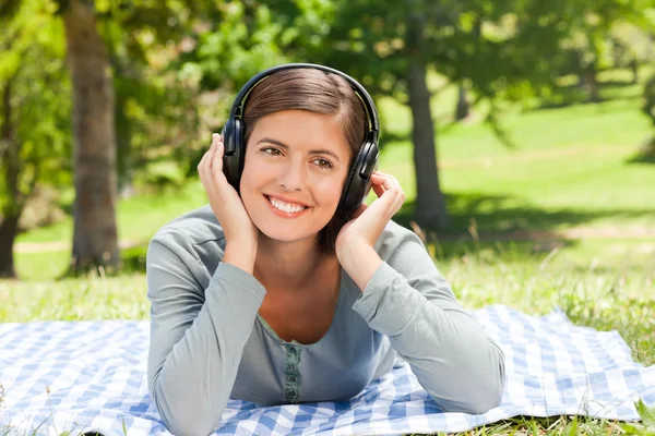 听一些音乐在公园里的女人 — 图库照片