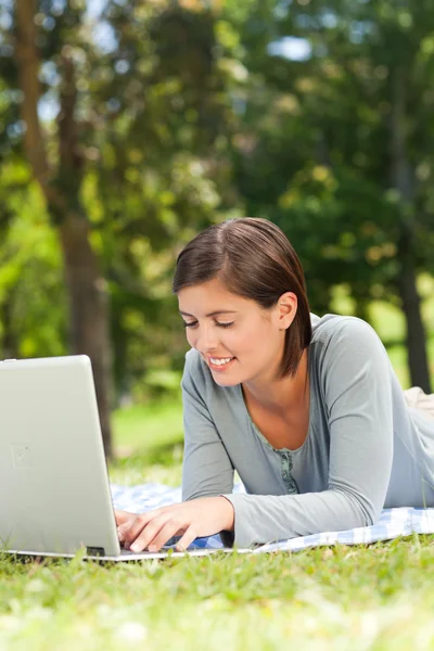 Vrouw die werkt op haar laptop in het park — Stockfoto