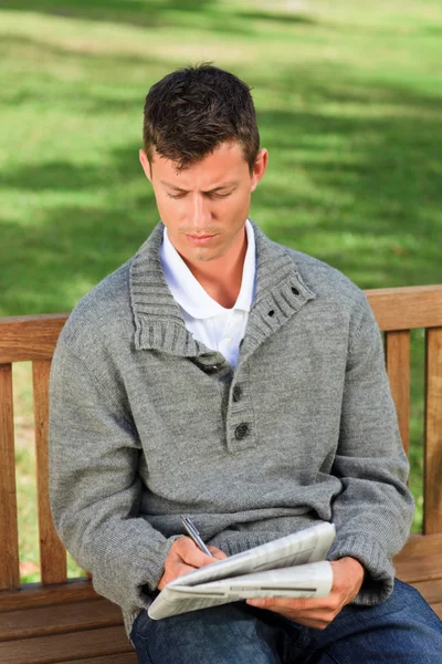 Handsome man making his crossword — Stock Photo, Image