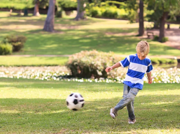 男孩在公园踢足球 — 图库照片