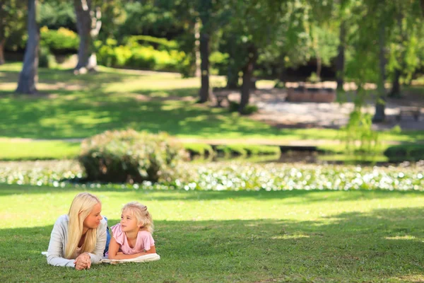 Матір з дочкою лежачи в парку — стокове фото
