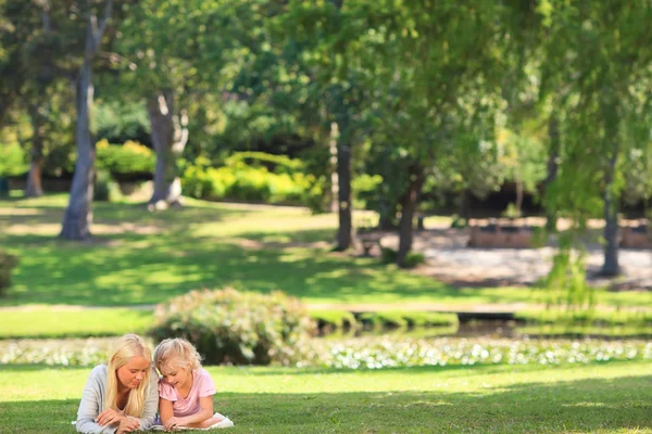 公園に横たわる彼女の娘を持つ母 — ストック写真