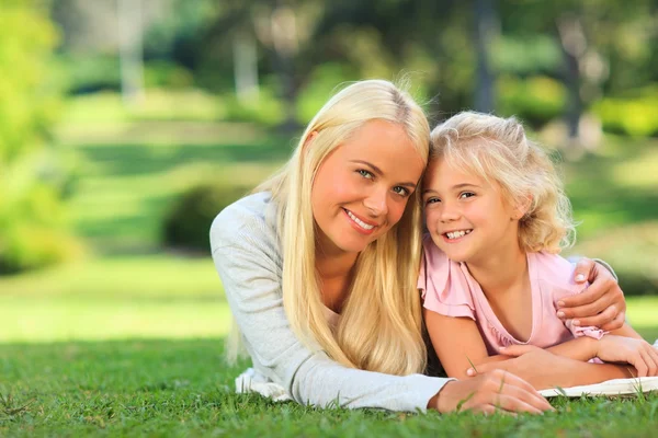 Madre con sua figlia sdraiata nel parco — Foto Stock
