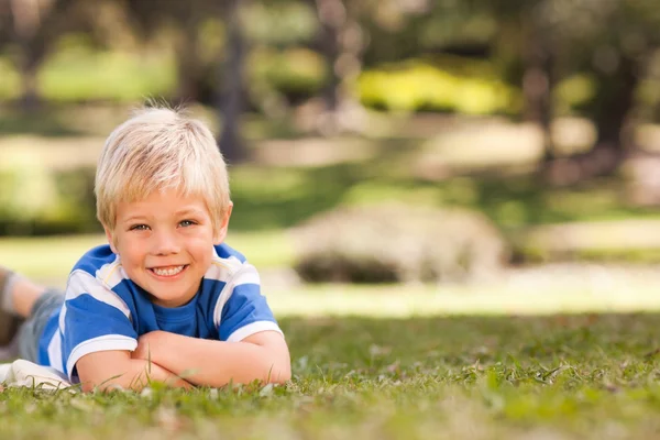 Chlapec vleže v parku — Stock fotografie