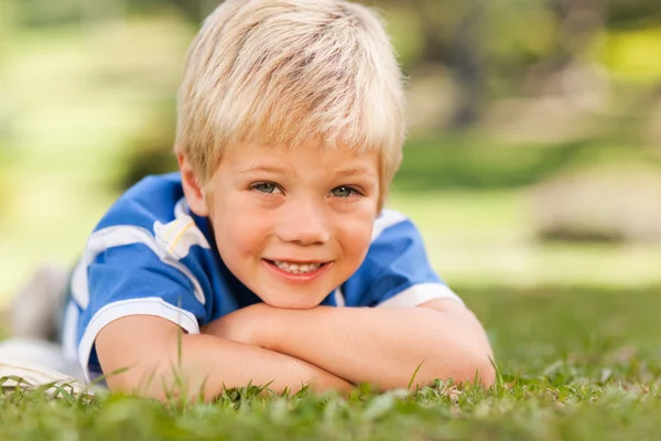 Boy lying down in the park — Stock Photo, Image