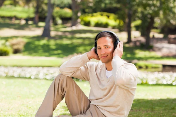 Человек, слушающий музыку в парке — стоковое фото