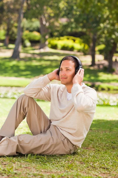 Man lyssnar på musik i parken — Stockfoto