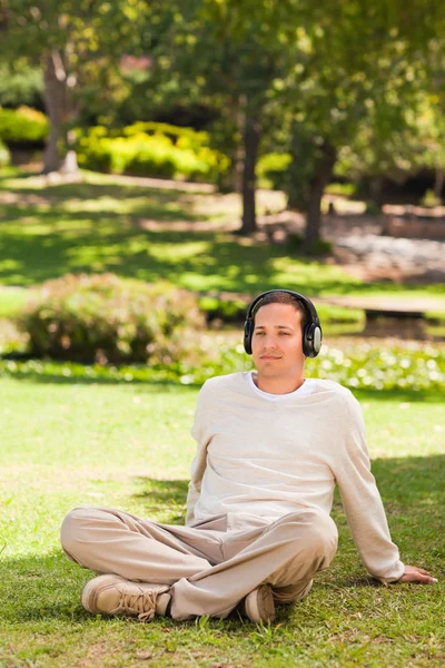 Człowiek słuchanie muzyki w parku — Zdjęcie stockowe