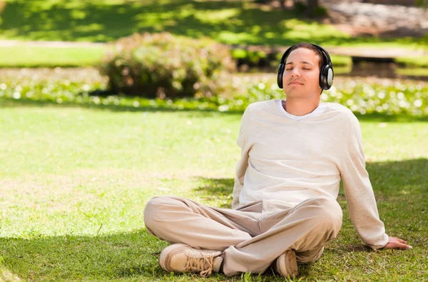 Man luisteren naar muziek in het park — Stockfoto