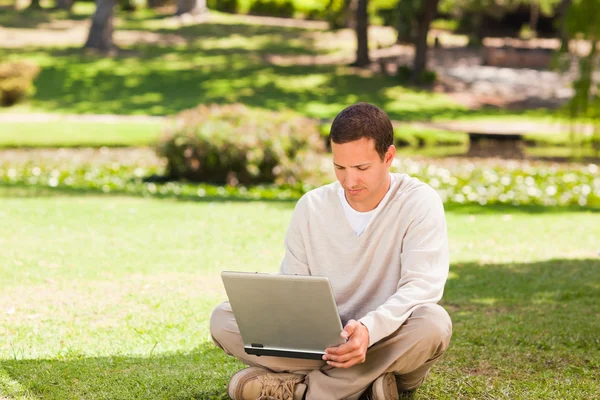Homem trabalhando em seu laptop no parque — Fotografia de Stock