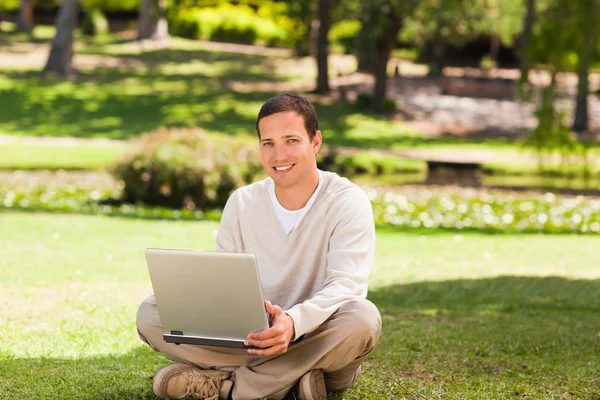 Homem trabalhando em seu laptop no parque — Fotografia de Stock