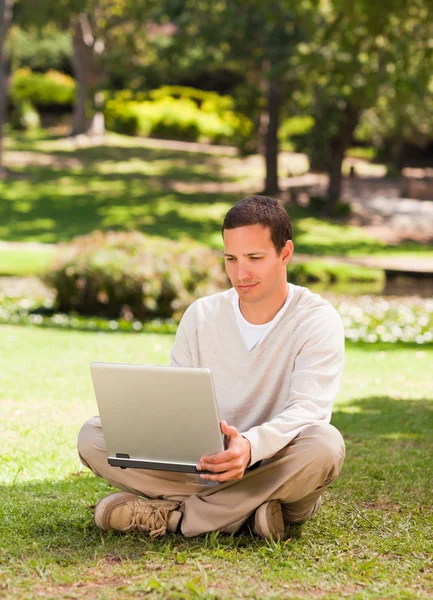 Mann arbeitet im Park an seinem Laptop — Stockfoto