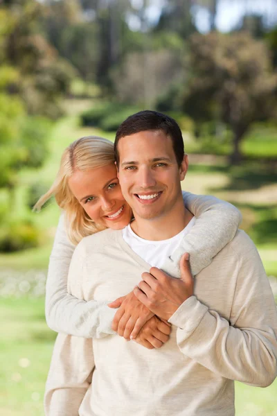 Kvinna kramar hennes pojkvän i parken — Stockfoto