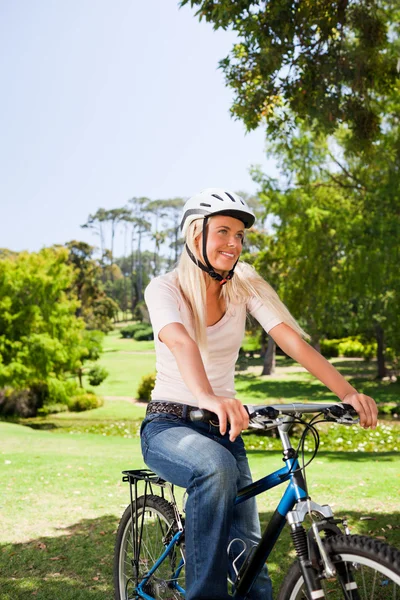 Kobieta w parku z nią na rowerze — Zdjęcie stockowe