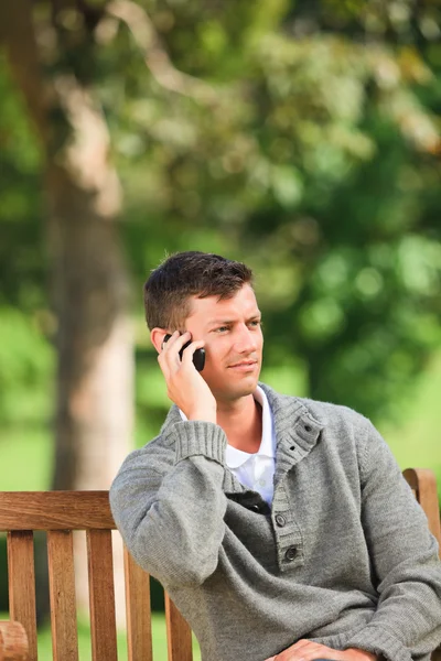 Man phoning on the bench — Stock Photo, Image