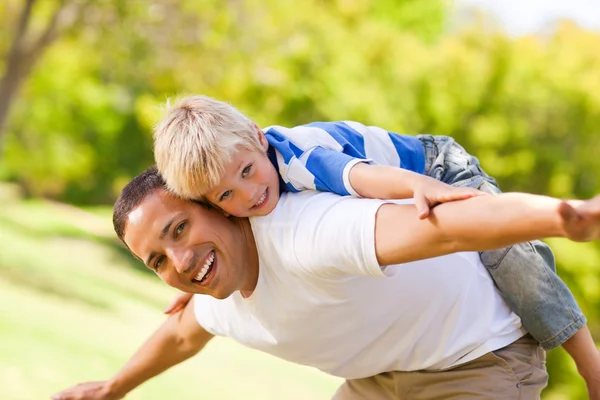 Son playing with his father in the park — Stock Photo, Image