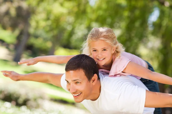 Klein meisje spelen met haar vader in het park — Stockfoto