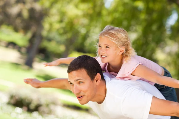 Klein meisje spelen met haar vader in het park — Stockfoto