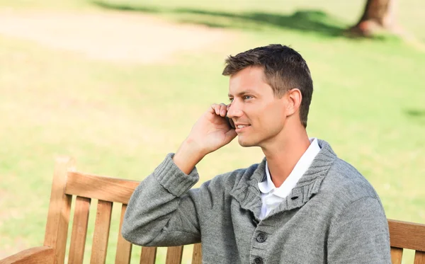 stock image Man phoning on the bench