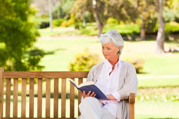 Mulher aposentada lendo um livro — Fotografia de Stock