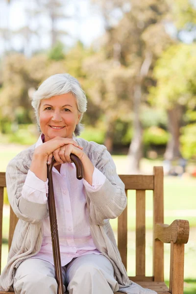Woman with her walking stick in the park — Stock Photo, Image