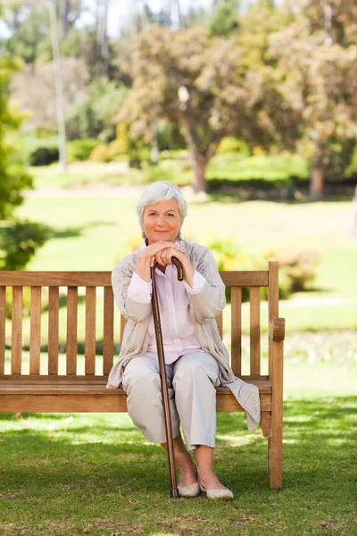 Woman with her walking stick in the park — Stock Photo, Image