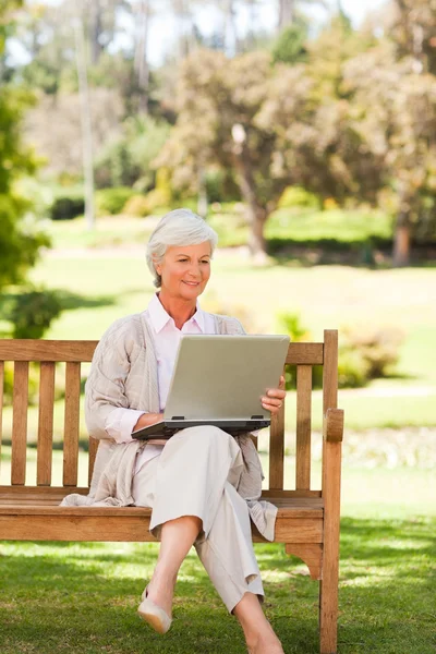 Mulher aposentada trabalhando em seu laptop — Fotografia de Stock