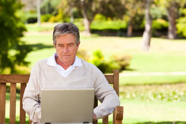 Старший человек работает над своим ноутбуком — стоковое фото