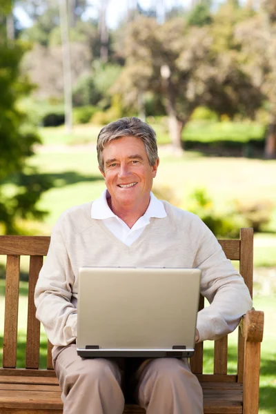 Starszy mężczyzna pracujący na swoim laptopie — Zdjęcie stockowe