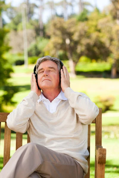 Retired man listening to some music — Stock Photo, Image
