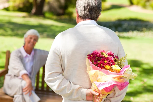 Emekli adam karısına çiçek sunan — Stok fotoğraf
