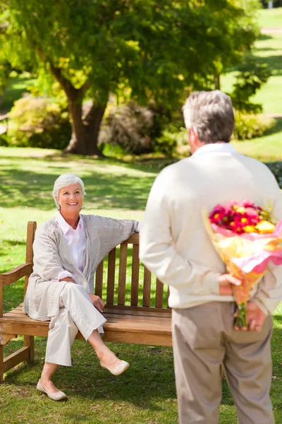 Retired man offering flowers to his wife — Stock Photo, Image