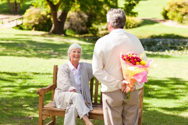 Uomo in pensione che offre fiori a sua moglie — Foto Stock