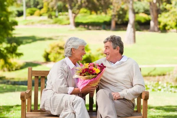 Senior man bloemen met zijn vrouw — Stockfoto