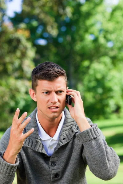 Junger Mann telefoniert auf der Bank — Stockfoto