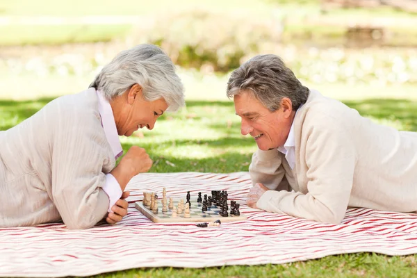 Пожилая пара играет в шахматы — стоковое фото