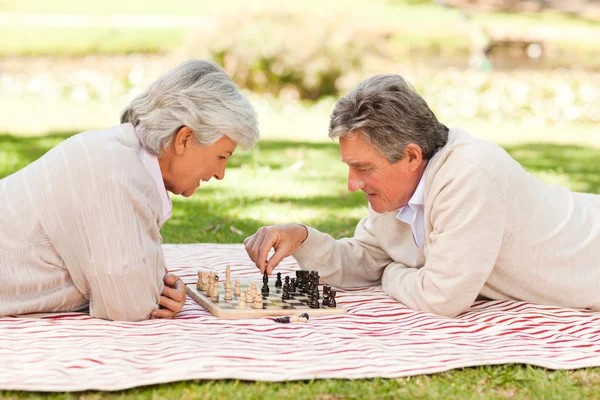 Couple âgé jouant aux échecs — Photo