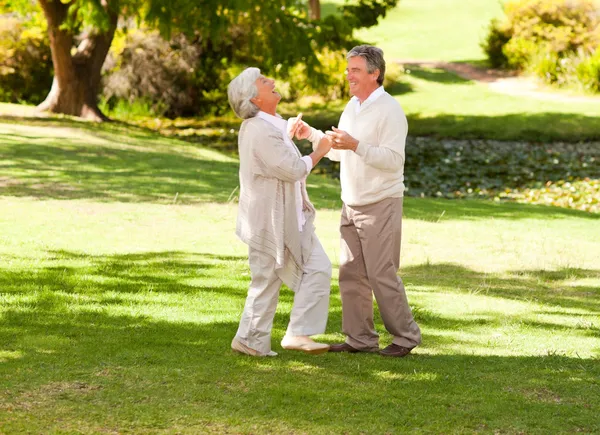 Mature couple dancing in the park — Stock Photo, Image