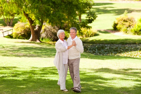 Зрелая пара танцует в парке — стоковое фото