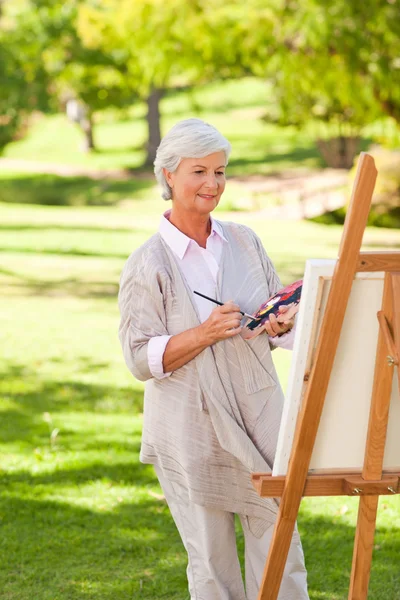 Ανώτερος γυναίκα ζωγραφική στο πάρκο — Φωτογραφία Αρχείου