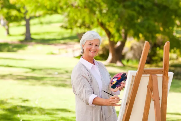 Mujer mayor pintando en el parque — Foto de Stock