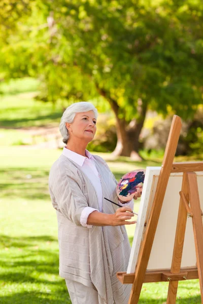 Senior woman painting in the park — Stock Photo, Image