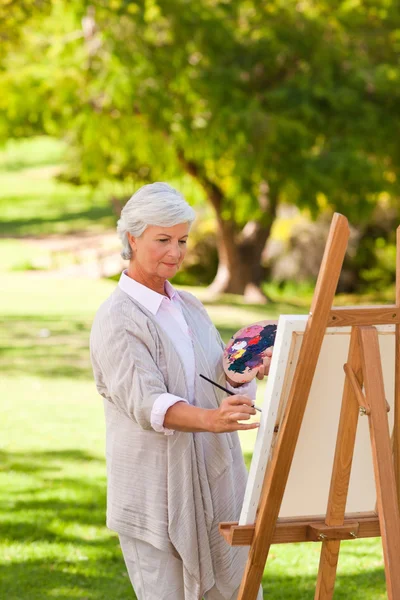 Старша жінка малює в парку — стокове фото