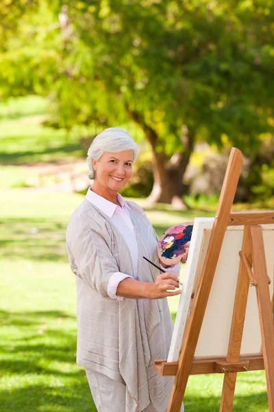 Старша жінка малює в парку — стокове фото