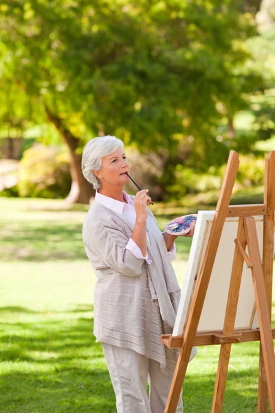 Ώριμη γυναίκα ζωγραφική στο πάρκο — Φωτογραφία Αρχείου