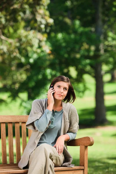 Woman phoning on the bench — Stock Photo, Image