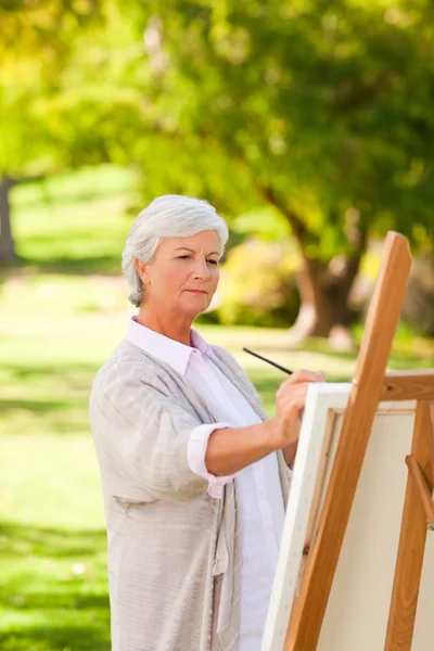 Mogen kvinna målning i parken — Stockfoto