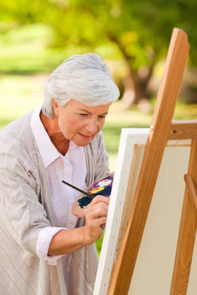 Volwassen vrouw schilderij in het park — Stok fotoğraf