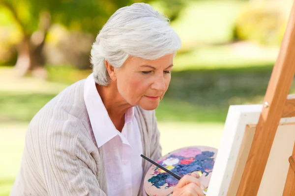 Зрелая женщина рисует в парке — стоковое фото